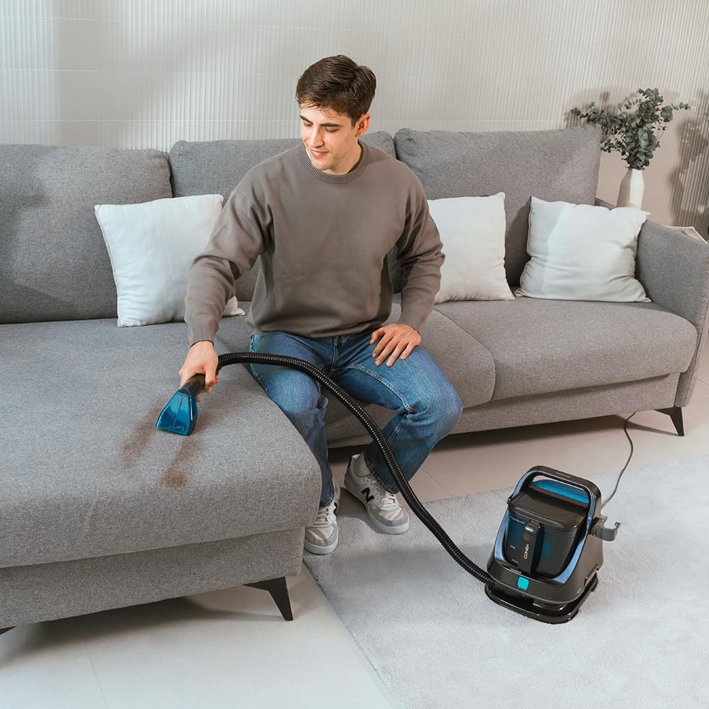 Man cleaning a sofa with the spot cleaner