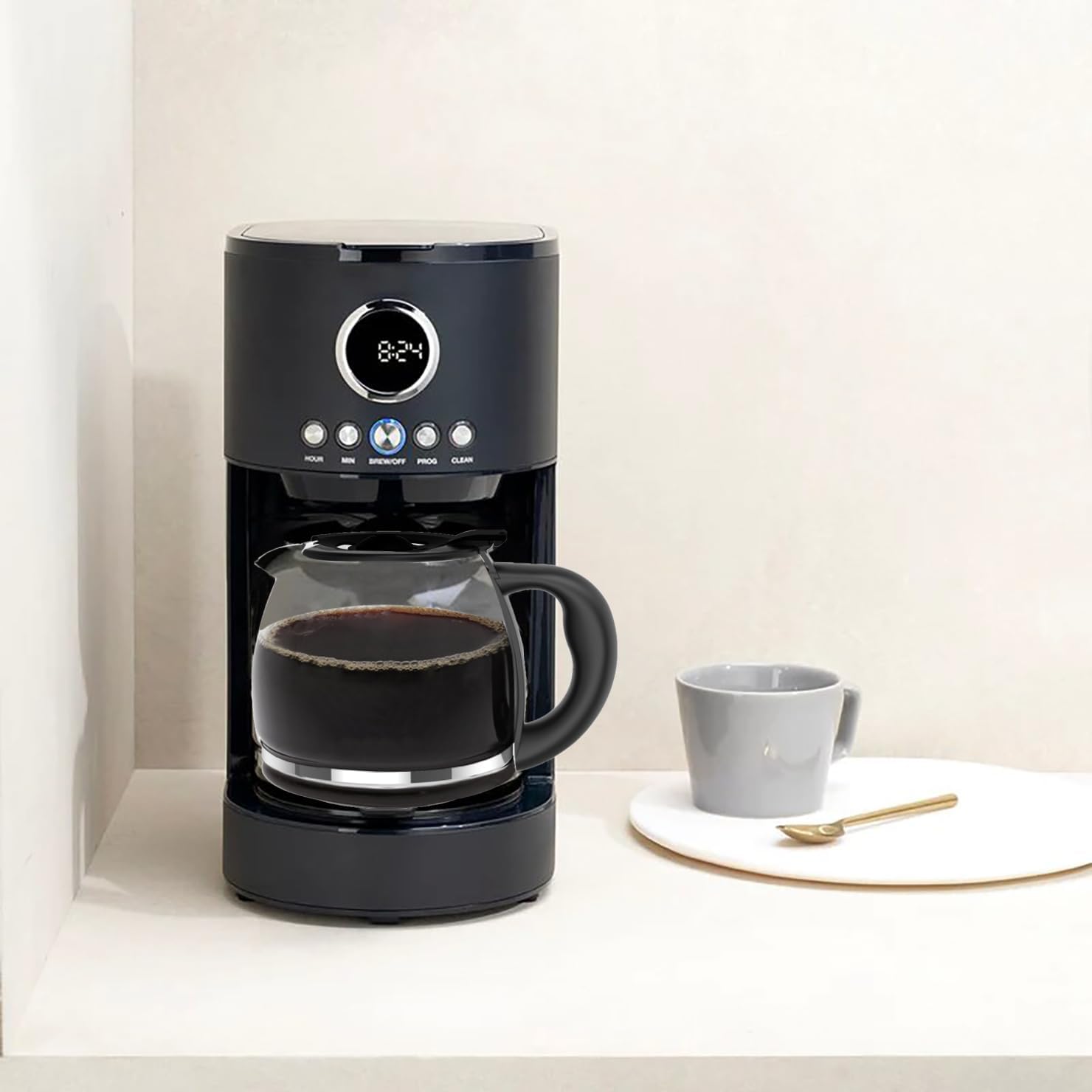 A cupsync replacement coffee pot filled with coffee, sitting in a Cuisinart DCC1220BKS coffee maker on a kitchen counter, with a coffee cup nearby.