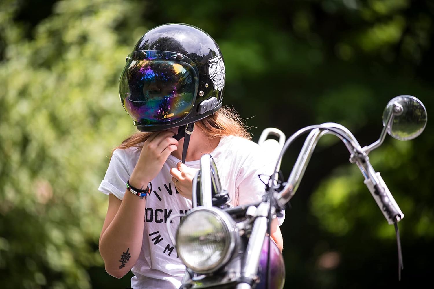Person adjusting the Sena 10R unit on their motorcycle helmet