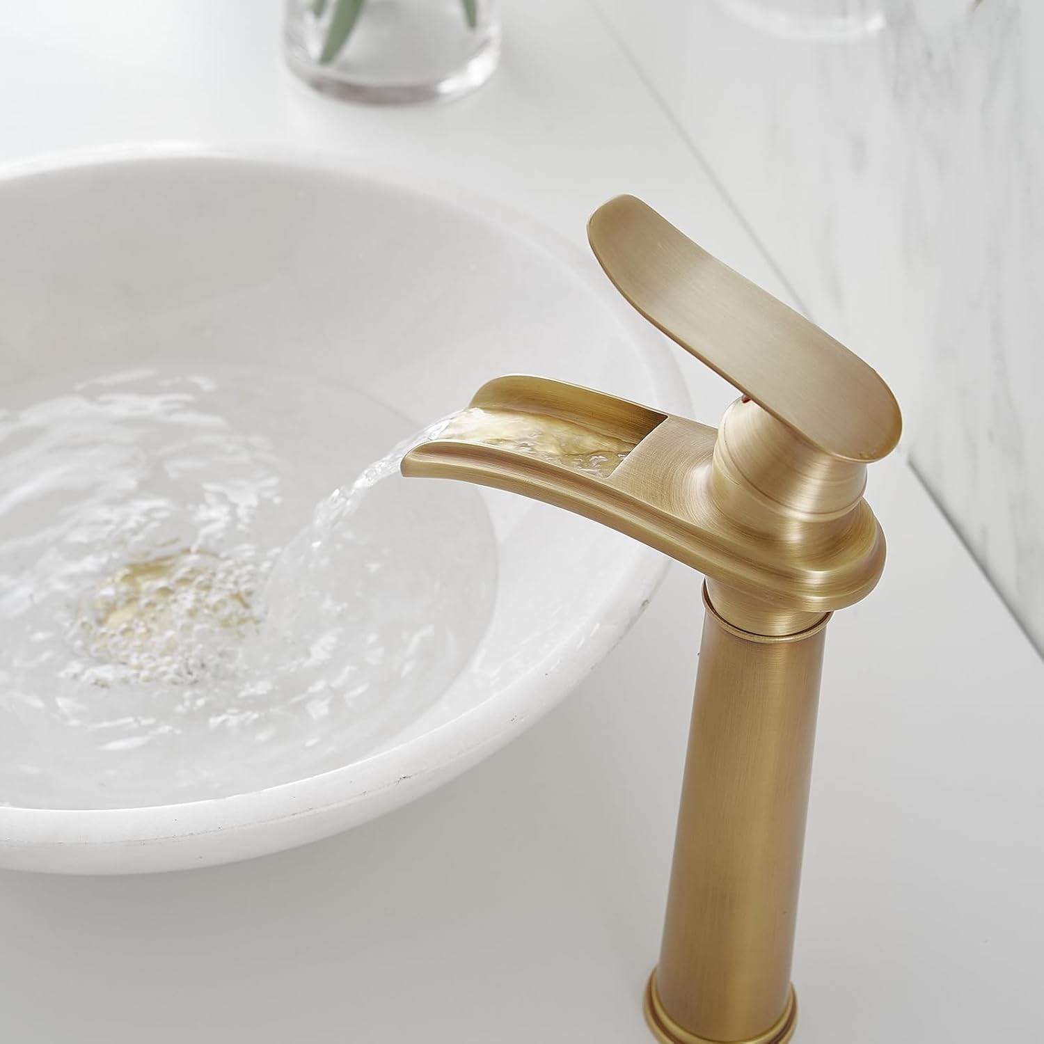 Close-up of the BWE waterfall faucet showing water flowing smoothly into a vessel sink