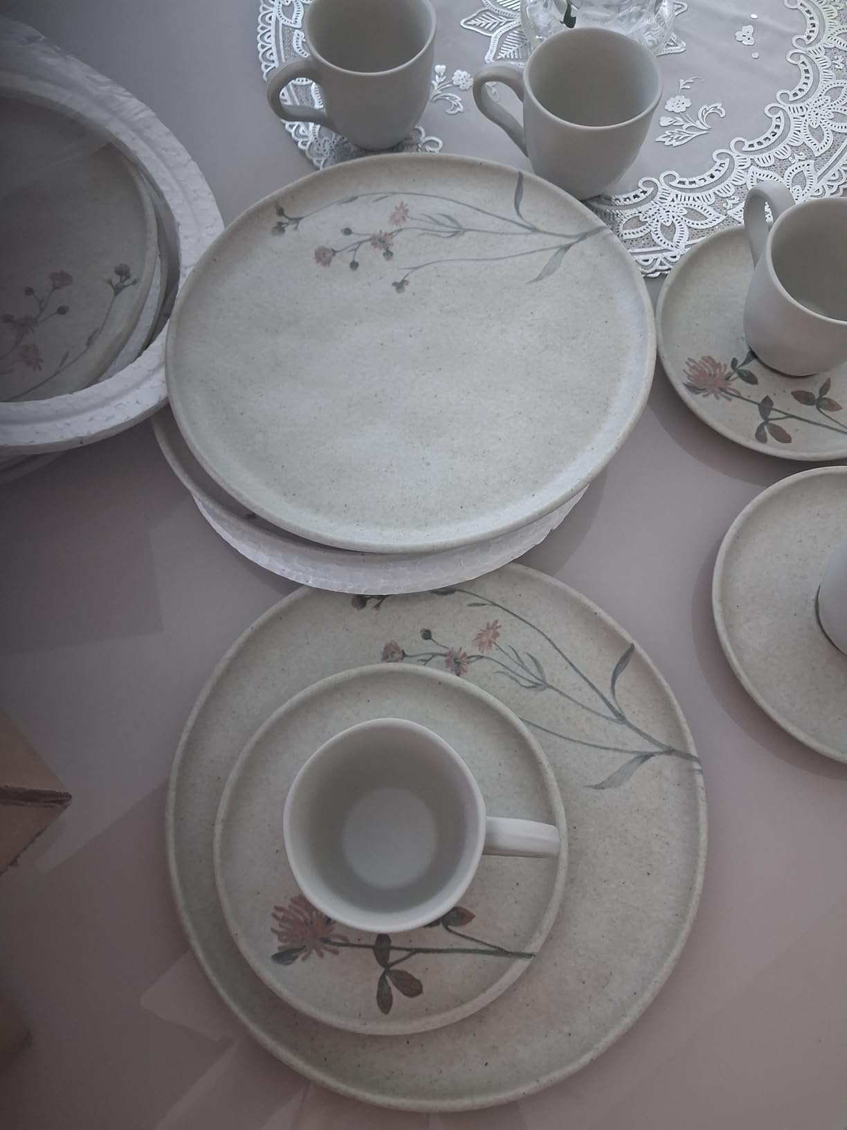 Mesa posta elegante com pratos de sobremesa Porto Brasil e xícaras de café sobre toalha de renda