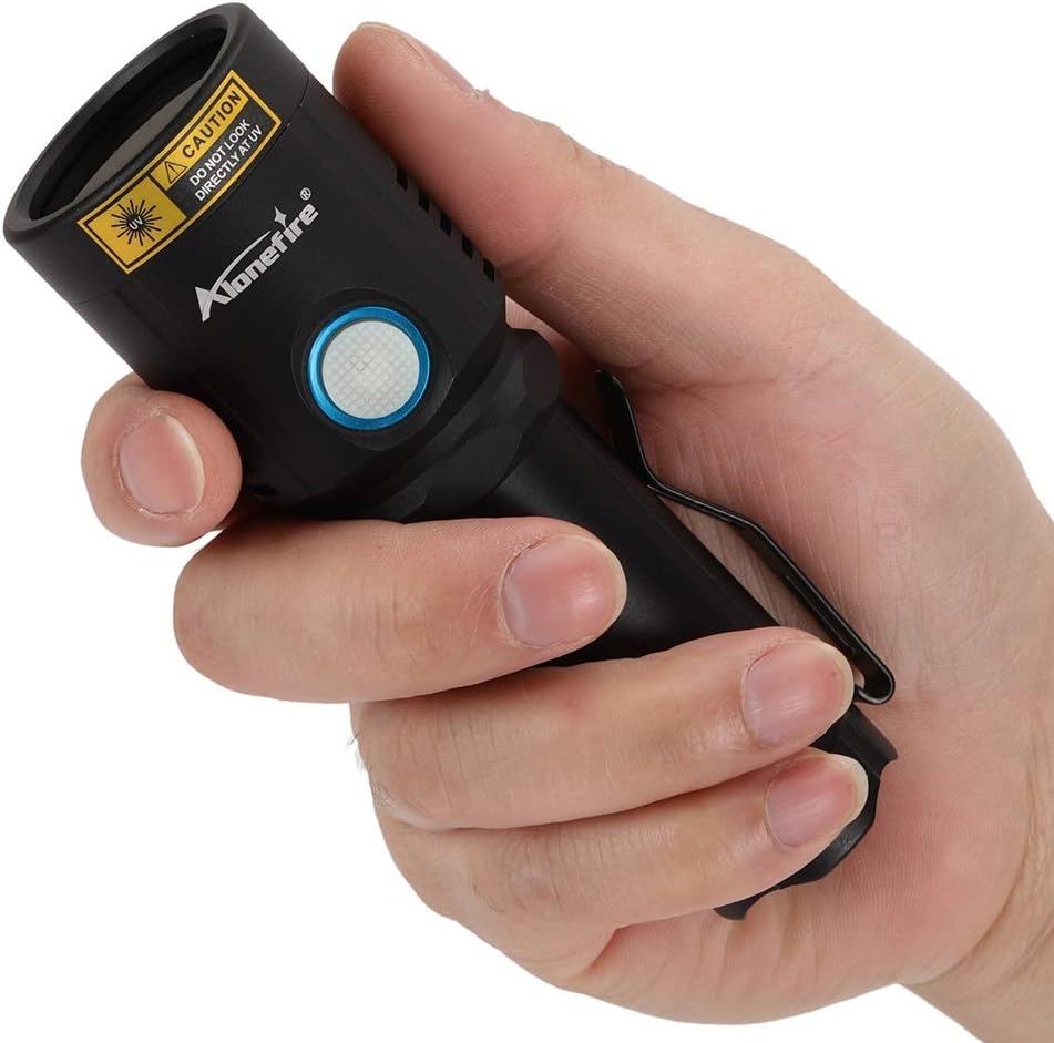 Hand holding the Alonefire X901UV flashlight, showing the side switch button