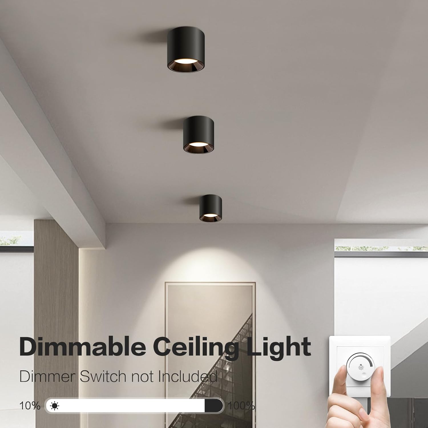 A hand adjusting a rotary dimmer switch, with three black cylindrical ceiling lights visible above, illustrating the dimmable feature.