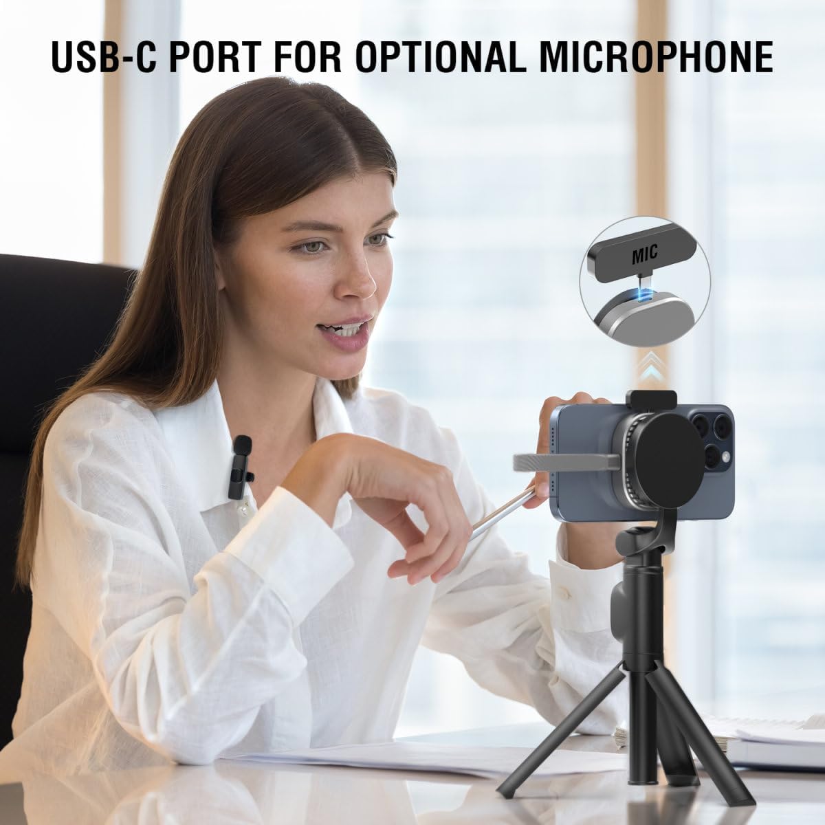 A person using an iPhone mounted on a tripod with the SSD enclosure attached, and a wireless microphone connected to the enclosure's USB-C 2.0 port.