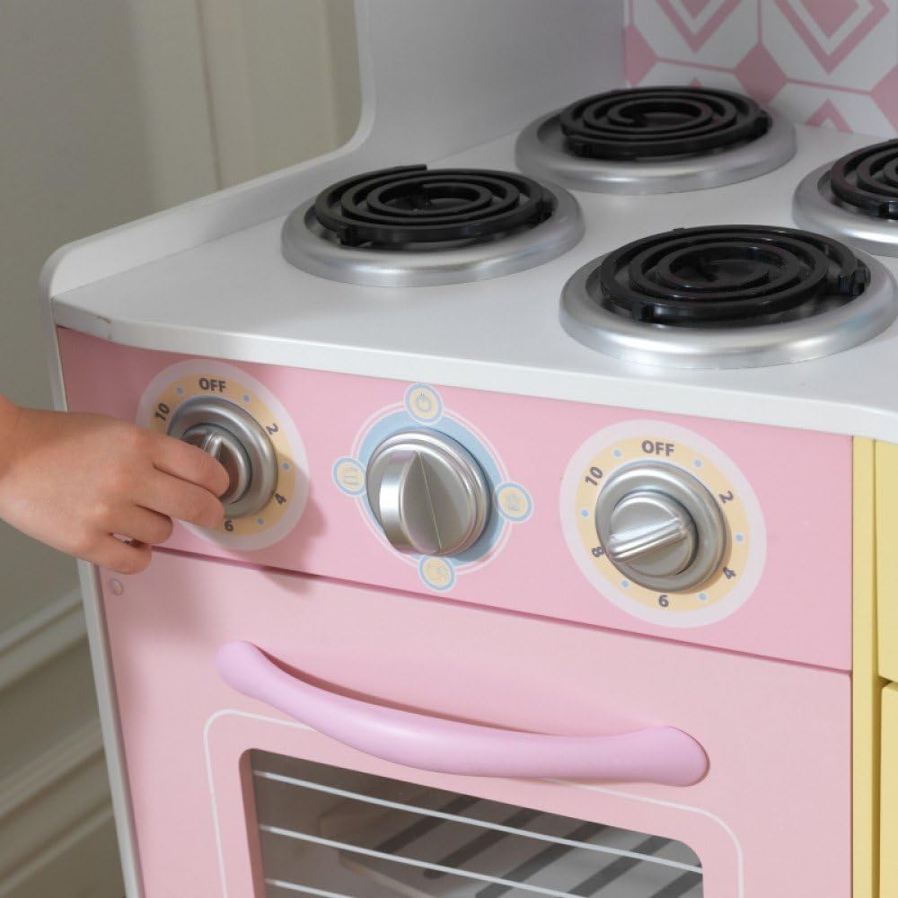 Child turning stove knob on play kitchen
