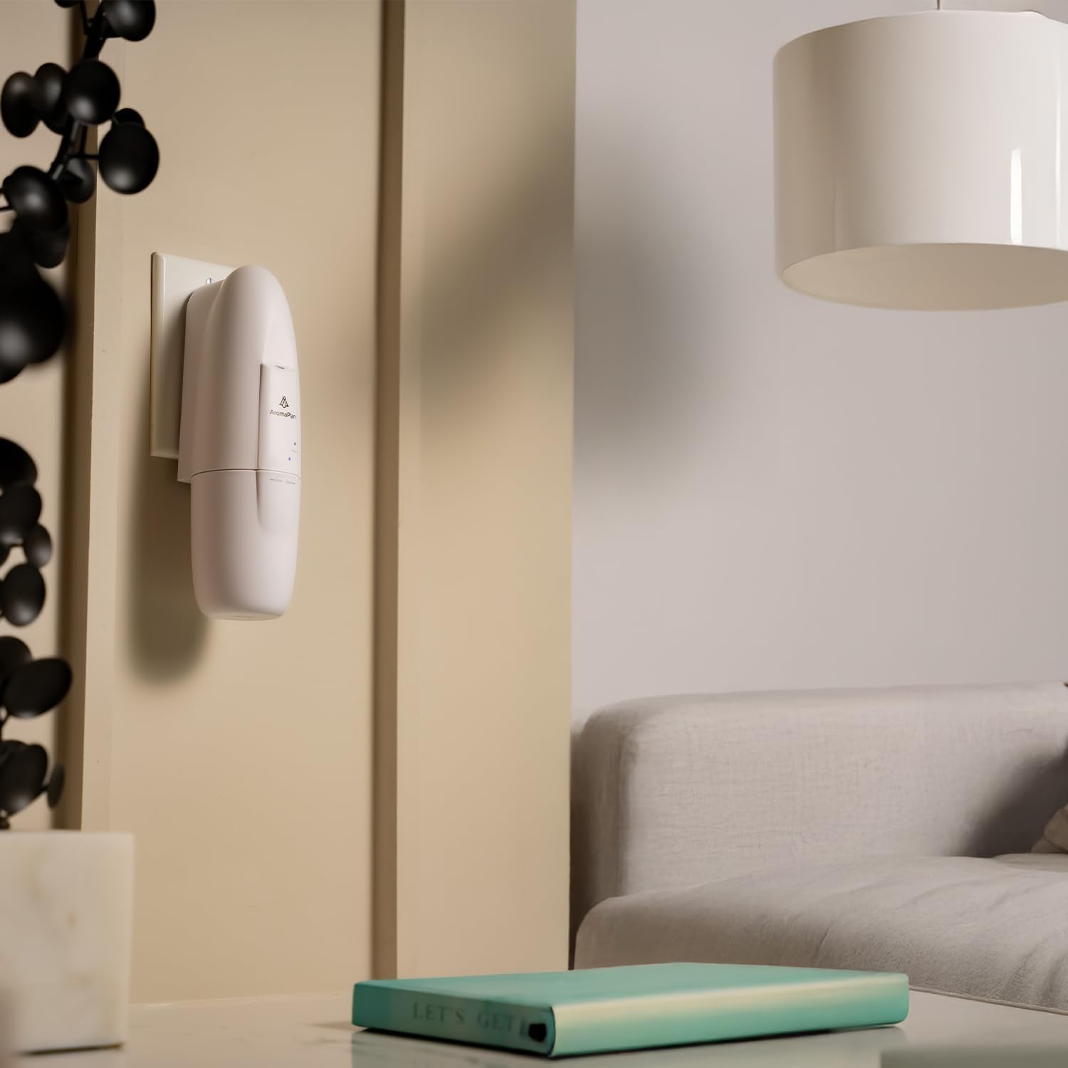 AromaPlan Plug-in Waterless Diffuser plugged into a wall outlet in a modern living room setting.