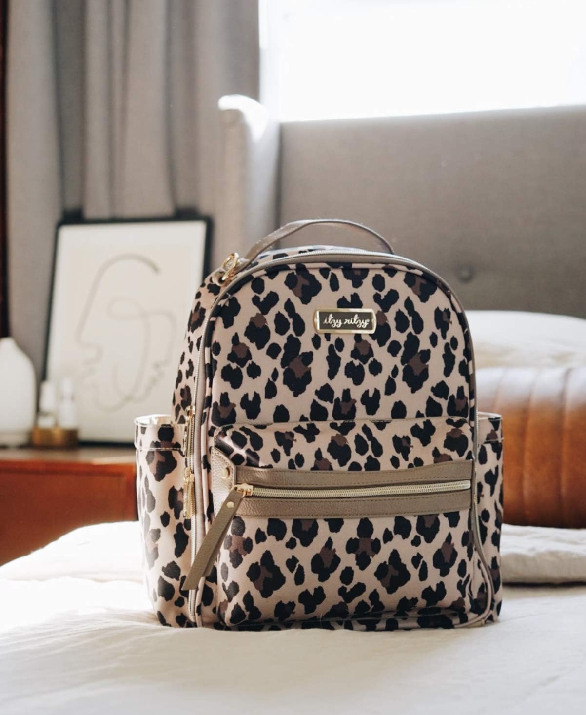 Itzy Ritzy Mini Diaper Bag Backpack – Chic Mini Diaper Bag with Changing Pad, 8 Total Pockets (4 Internal and 4 External), Grab-Top Handle and Rubber Feet (Leopard)
