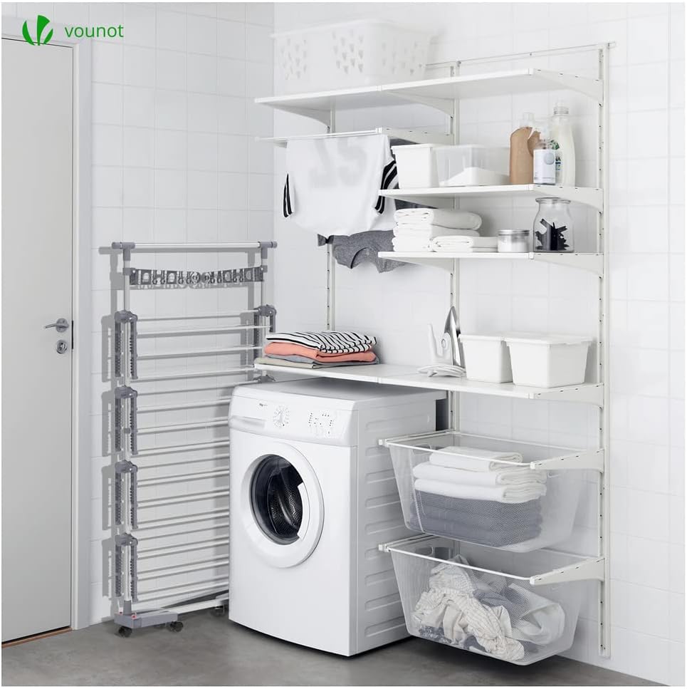 VOUNOT 4-Tier Vertical Tower Clothes Drying Rack folded and stored next to a washing machine.