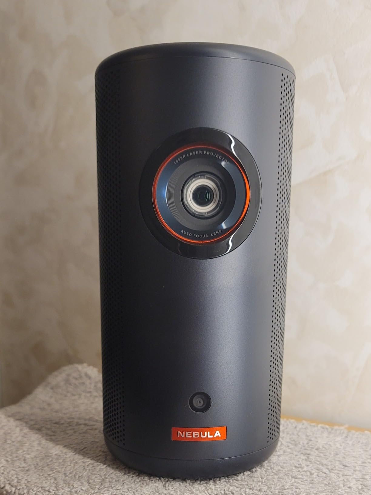 Anker Nebula projector on a wooden table in a dim living room