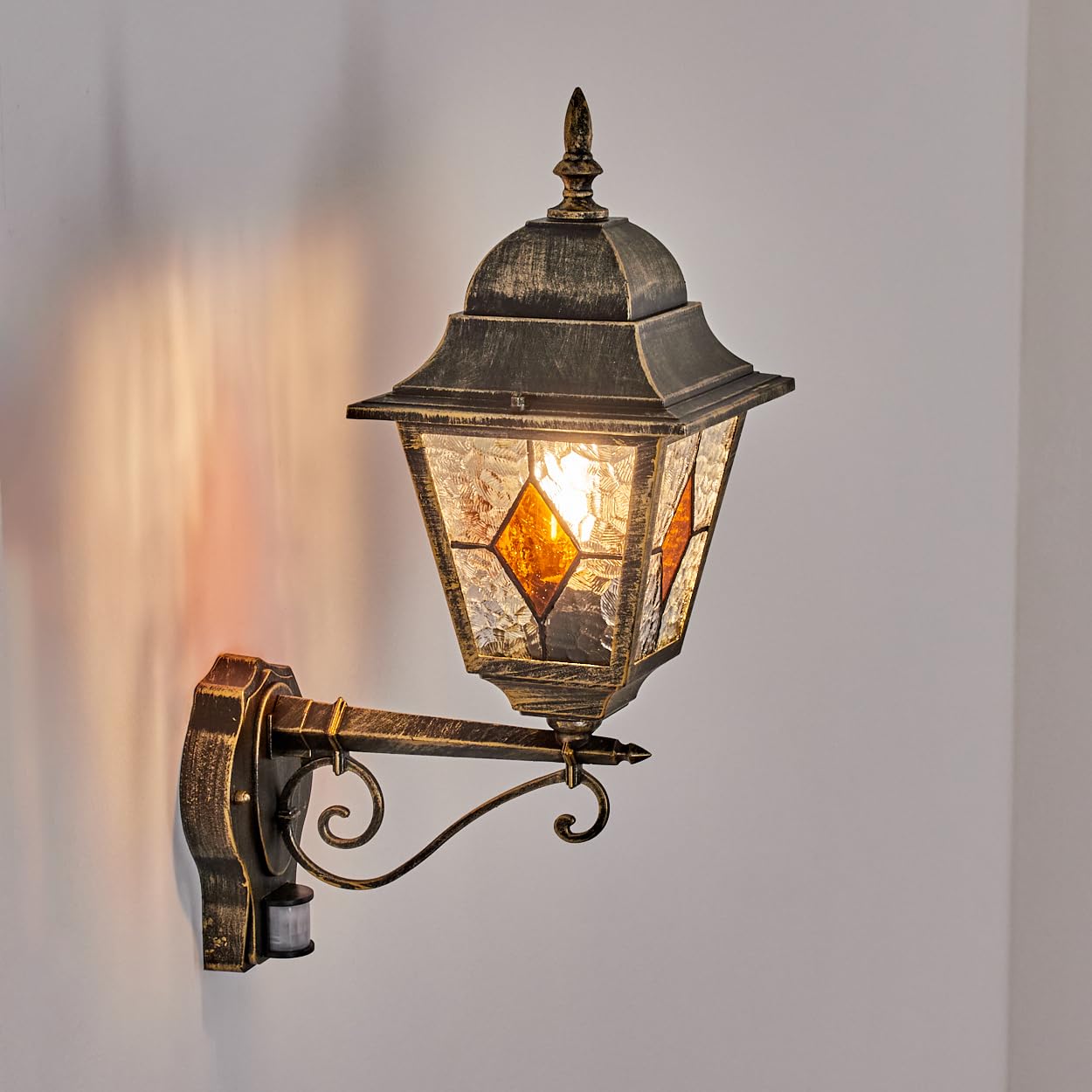 HOFSTEIN Außenwandleuchte Chatelain, Außenwandlampe m. Bewegungsmelder aus Metall/Glas in Gold/Schwarz/Klar/Bernstein, Wandleuchte außen aufwärts, Vintage/Antik/Landhaus für Garten, Haustür, E27, IP44