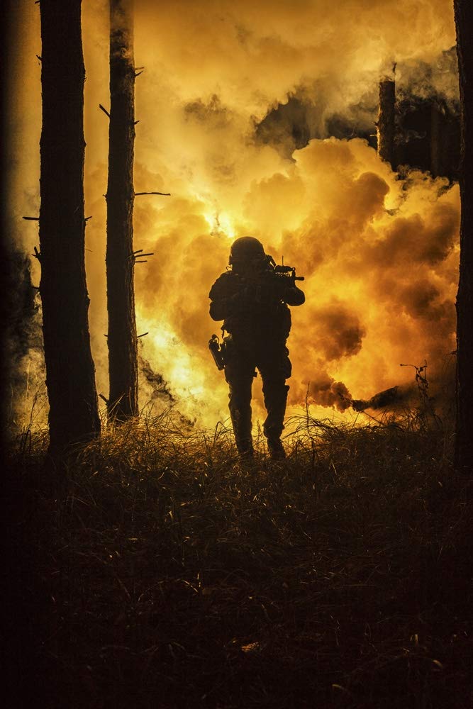 Silueta retroiluminada de operador marino de las fuerzas especiales en el bosque con explosión de fuego en el fondo. Póster impreso por Oleg Zabielin/Stocktrek Images (11 x 17)