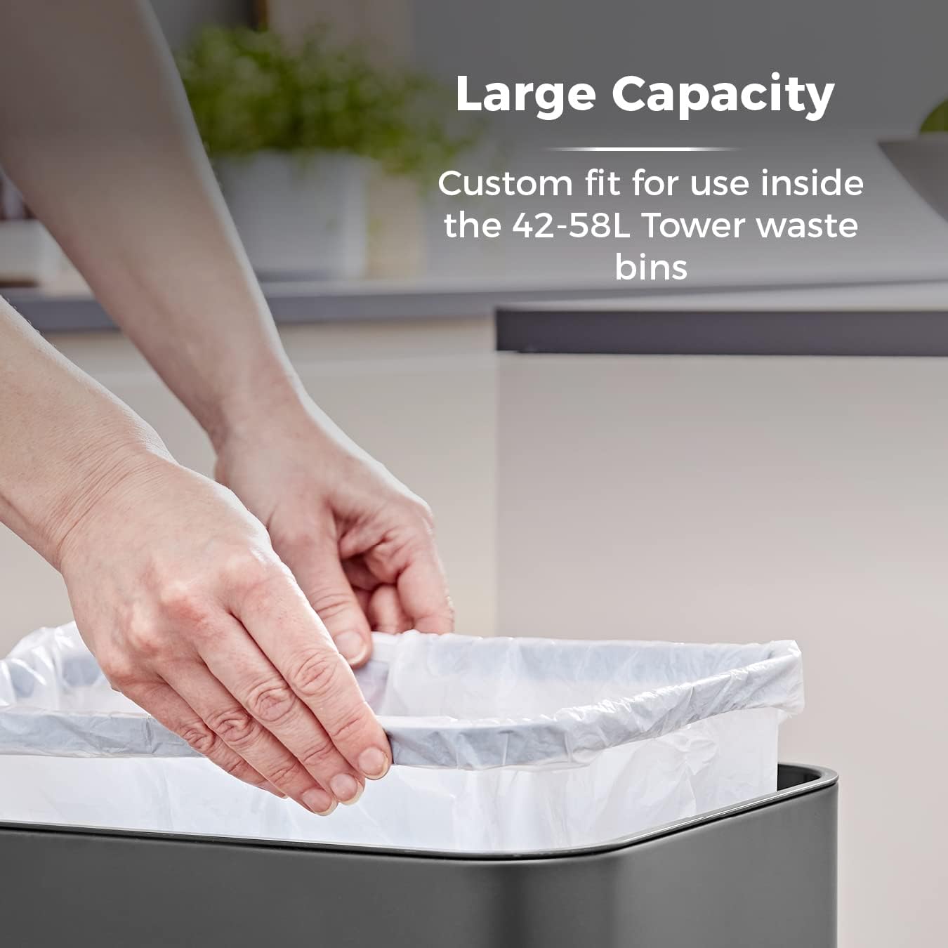 Hands placing a white bin liner into a dark grey waste bin.