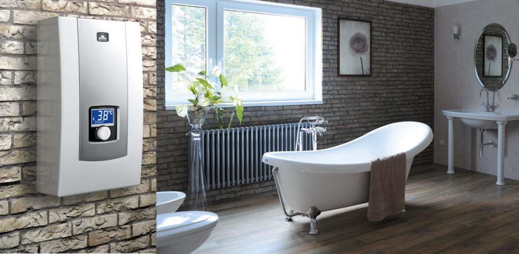 Kospel PPE2 water heater installed on a brick wall in a modern bathroom with a freestanding bathtub