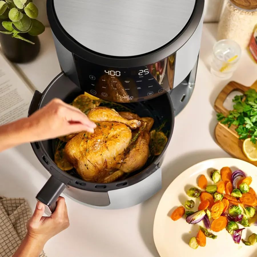 Person placing whole chicken into air fryer basket