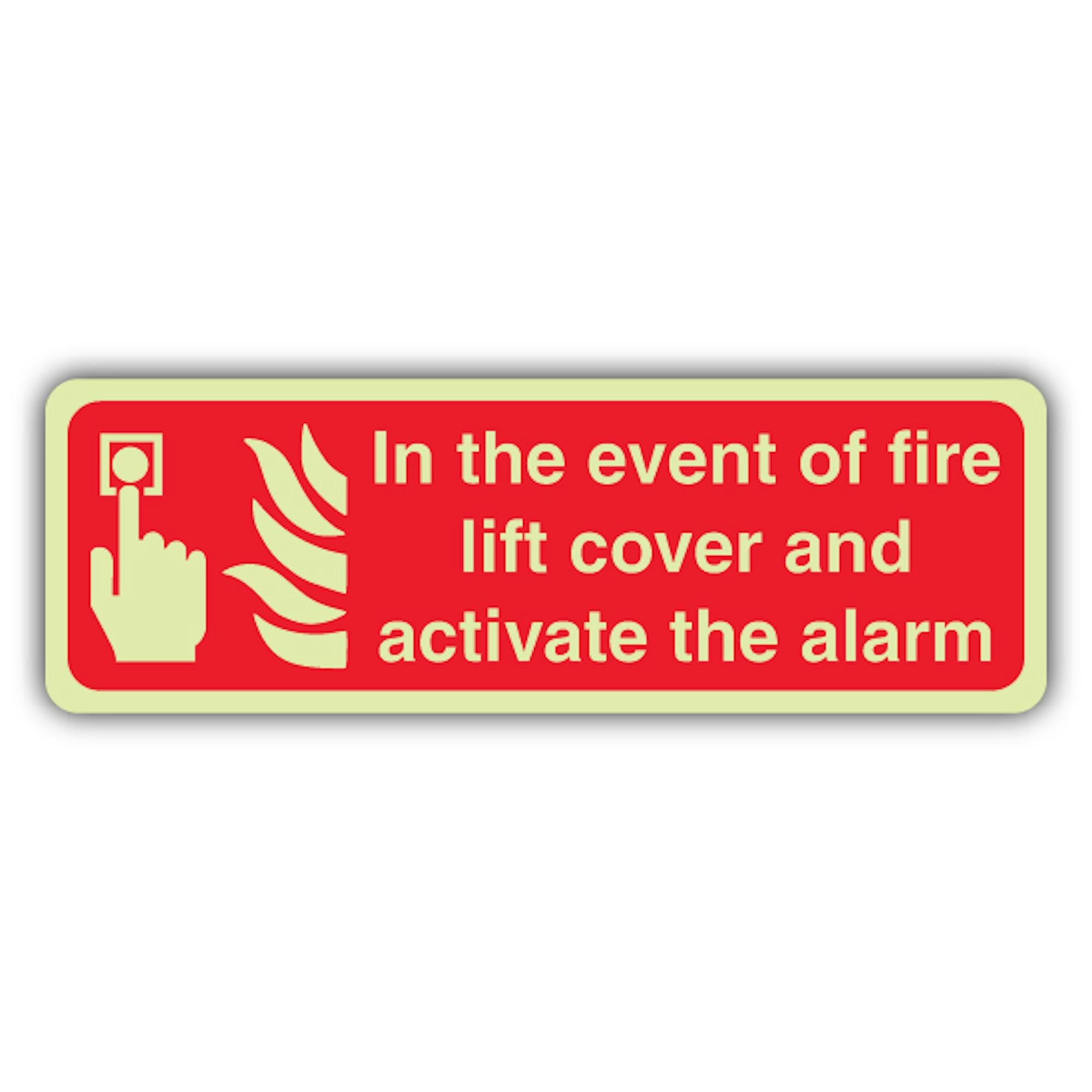 V Safety Glow In The Dark In The Event Of Fire Lift Cover & Activate The Alarm Sign - Formato delgado - 600 x 200 mm - Hecho de plástico rígido de triple brillo - Señalización de seguridad contra
