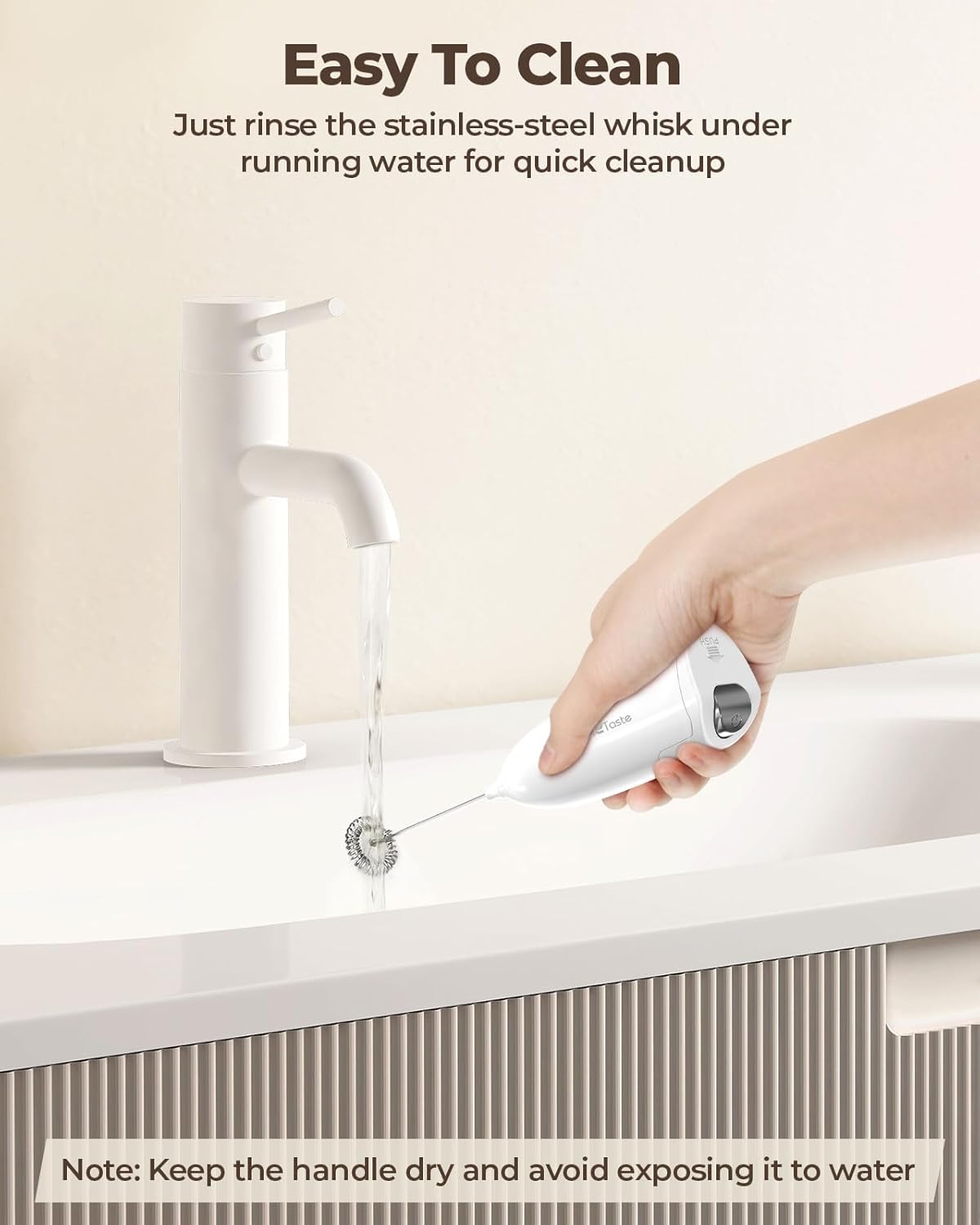 Hand rinsing the stainless steel whisk of the milk frother under running water from a faucet