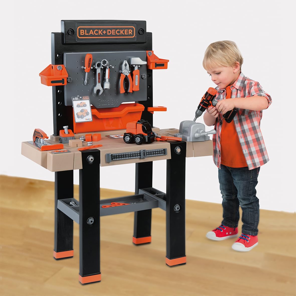 A young boy using the mechanical cordless screwdriver on the workbench