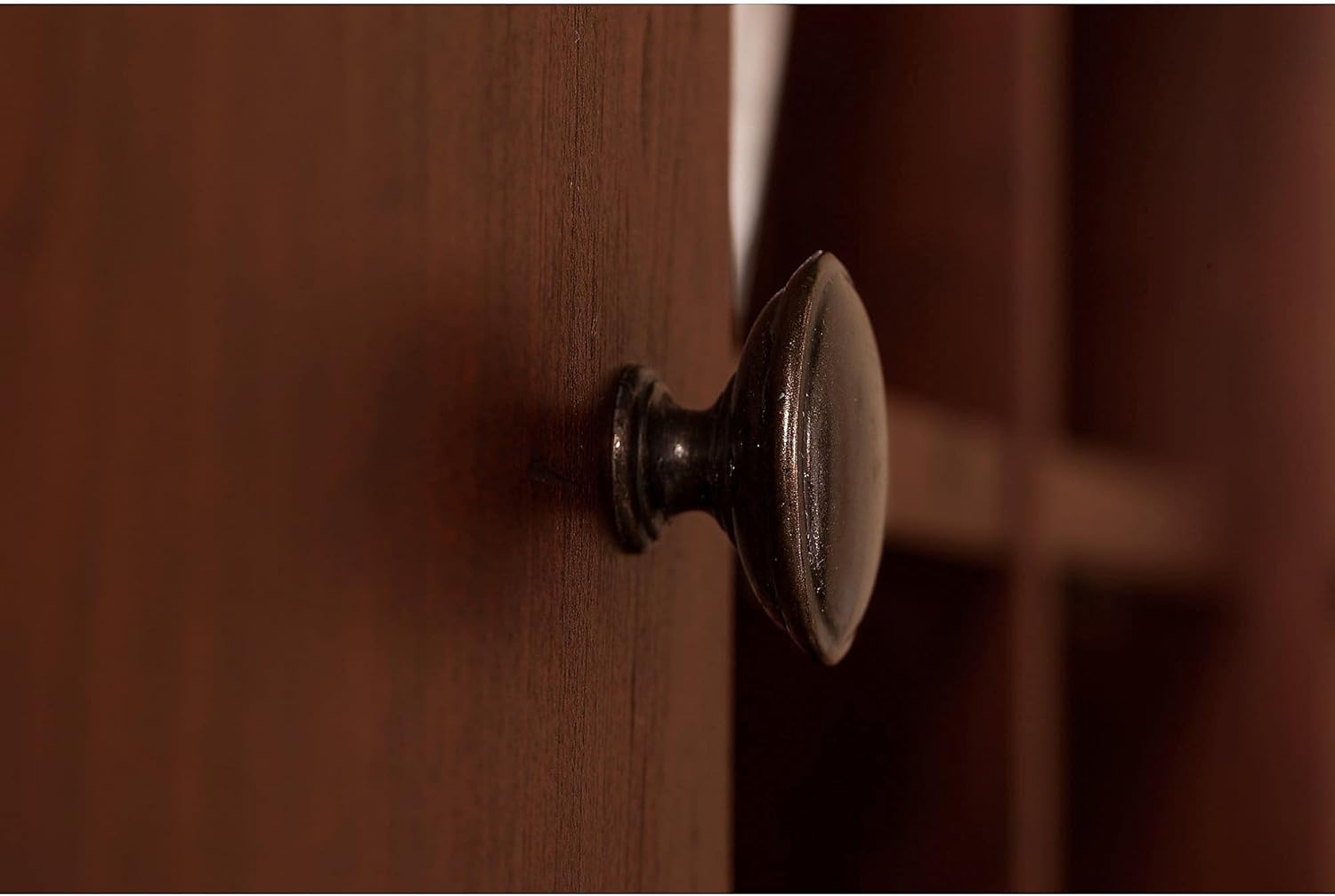Close-up of an oil-rubbed bronze knob on a cabinet door of the hutch.
