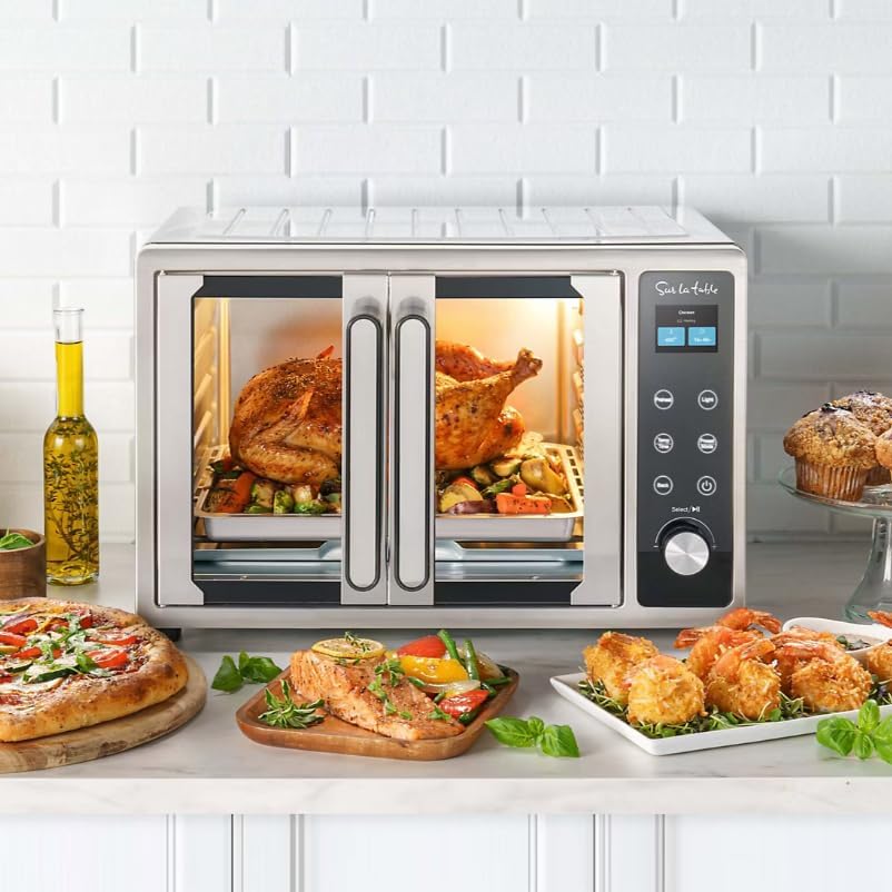 Sur La Table SLT-1832 French Door Air Fryer Toaster Oven with both French doors open, revealing a baking tray with roasted chicken and vegetables, and an air fry basket below.