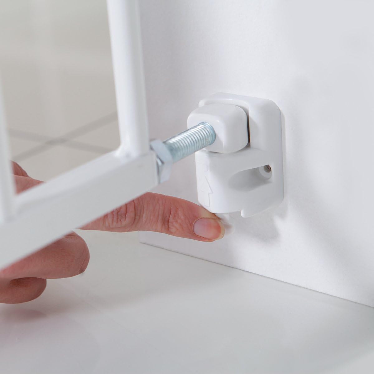 A finger pressing the release button on the safety gate to open it.