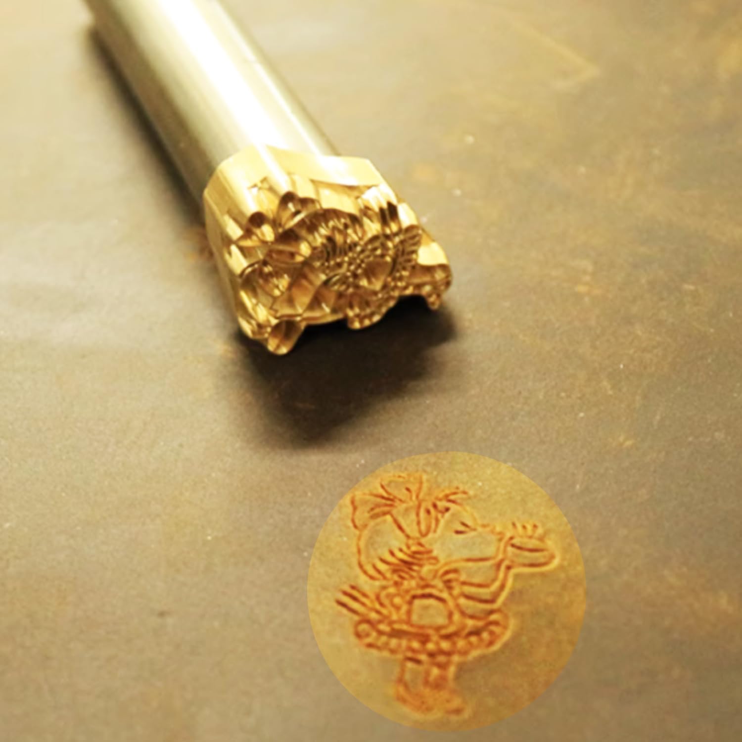 Close-up of a custom leather stamp with a detailed design, next to a piece of leather with the same design clearly imprinted.