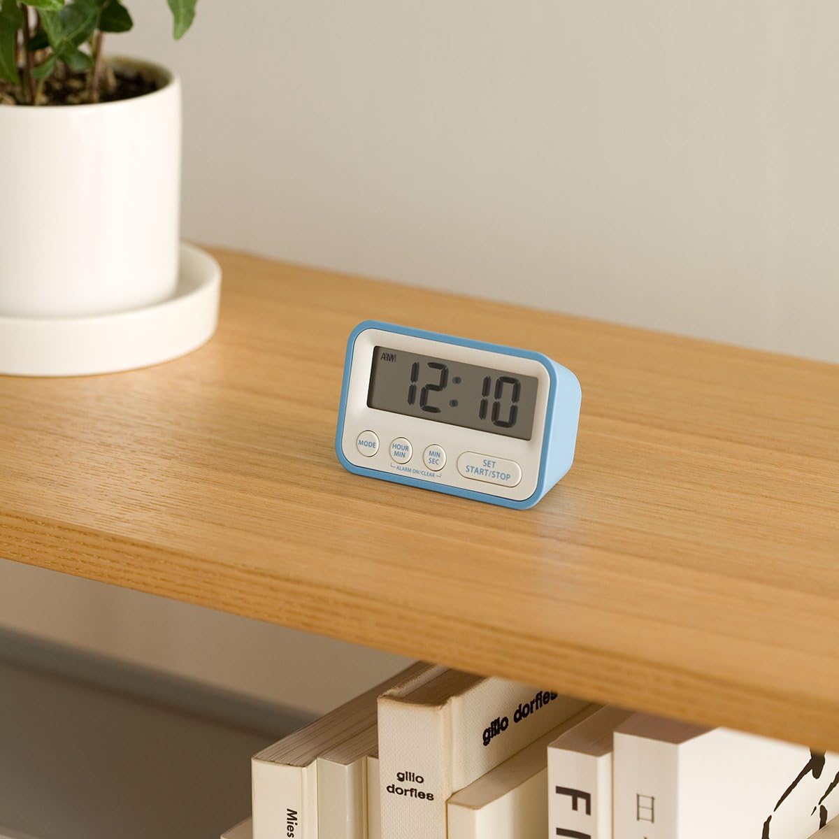 Mondo DK01-WH Digital Alarm Clock placed on a wooden shelf