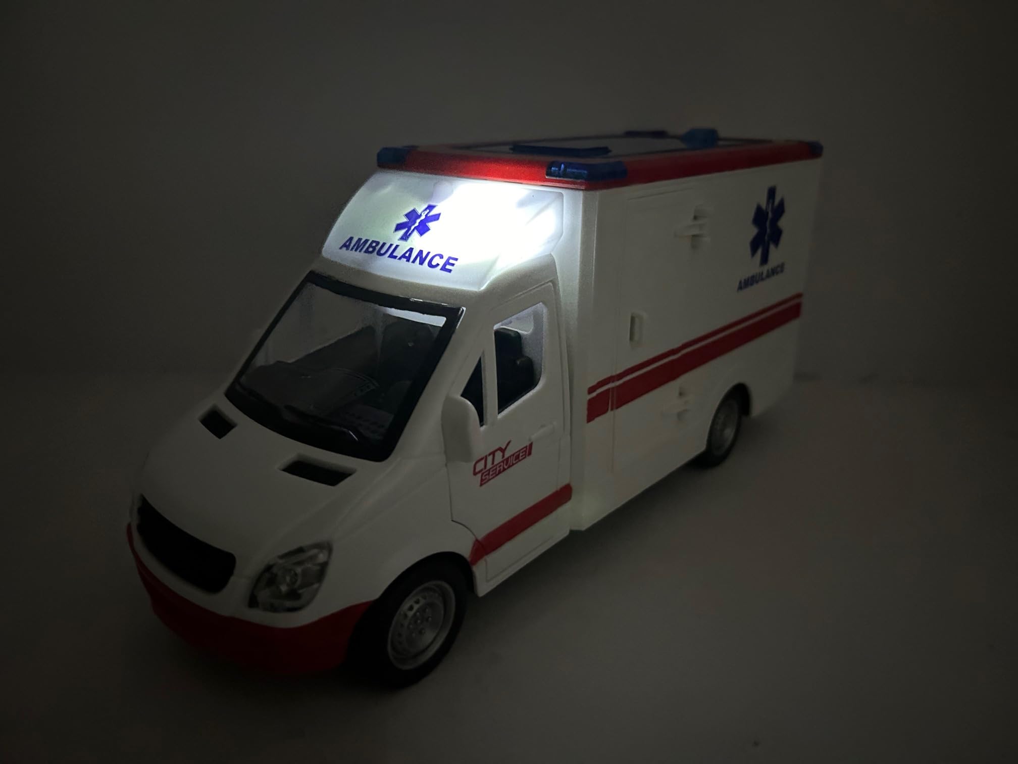 Ambulance Jouet avec Lumières Sons Sirènes Portes et Toit Ouvrables Mouvement Embrayage Grande Échelle 1:16 cm 26 Premiers Soins avec Lumière Sons Civière Amovible Enfants