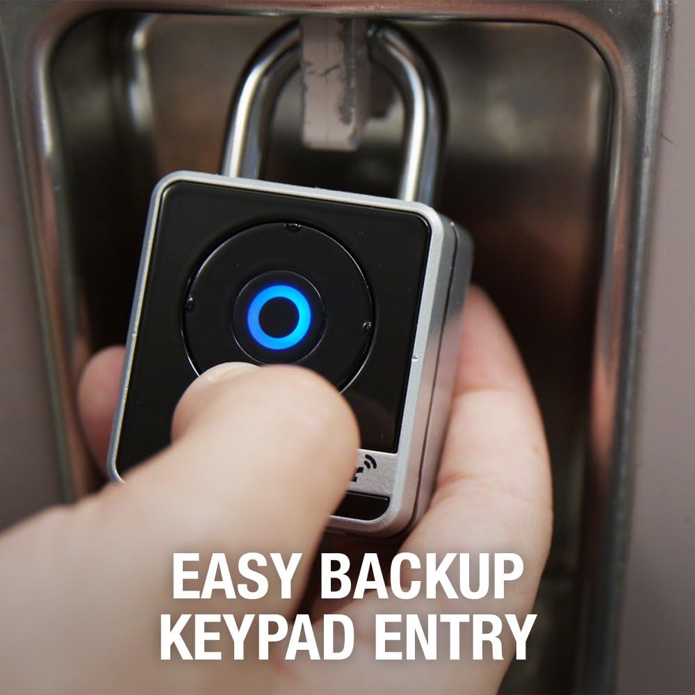 A hand pressing the center button on the Master Lock 4400D for backup keypad entry.