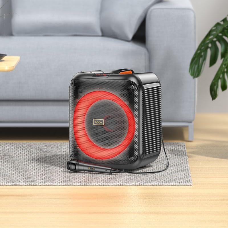 HOCO HA1 speaker with a wired microphone placed in front, showing the speaker's red LED lights.