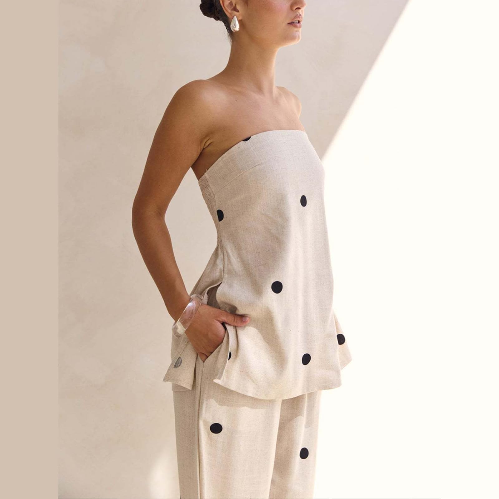 Ensemble deux pièces à pois pour femme : haut bustier sans bretelles et pantalon large taille haute. Collection été 2026.
