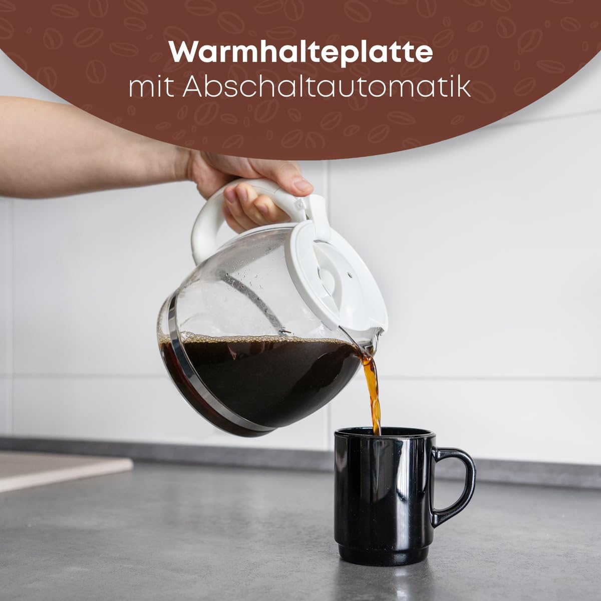 Hand pouring coffee from Clatronic KA 3473 carafe into a mug