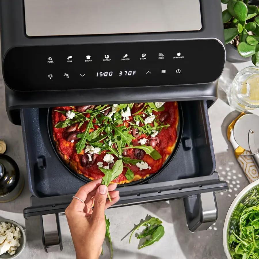 The bella-PRO 5-in-1 Indoor Grill and Air Fryer with its drawer pulled out, showing a pizza inside.