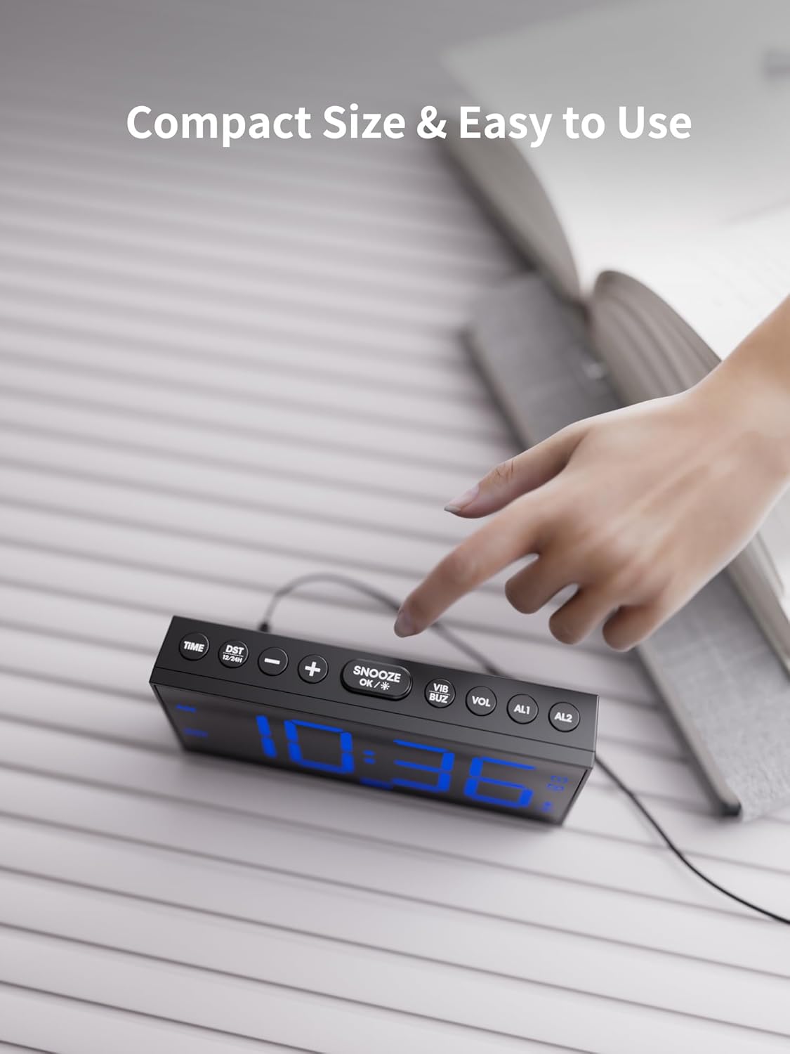 A hand pressing the large snooze button on top of the ROCAM alarm clock.