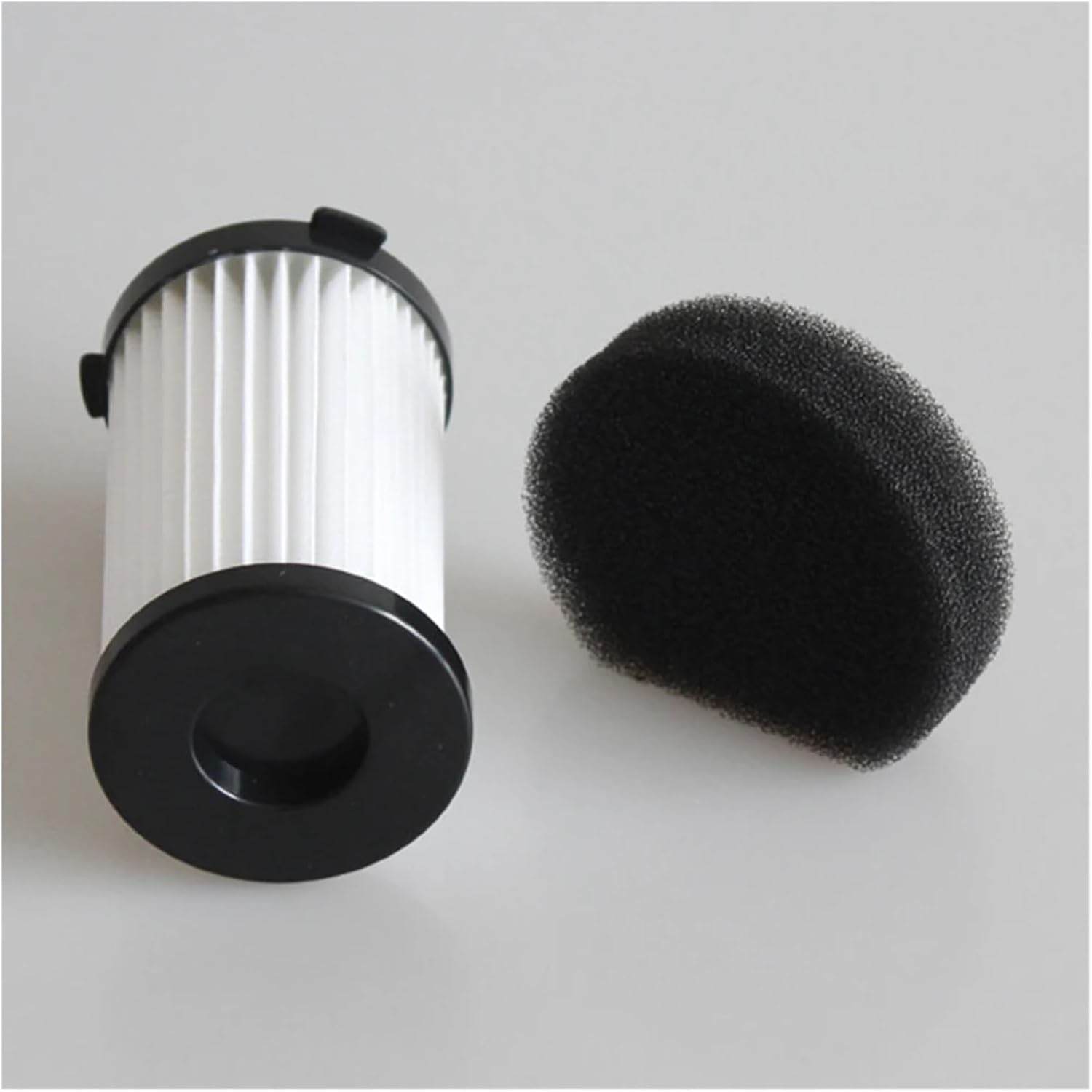 Bottom view of a white cylindrical filter with a black base, next to a black semi-circular foam piece.