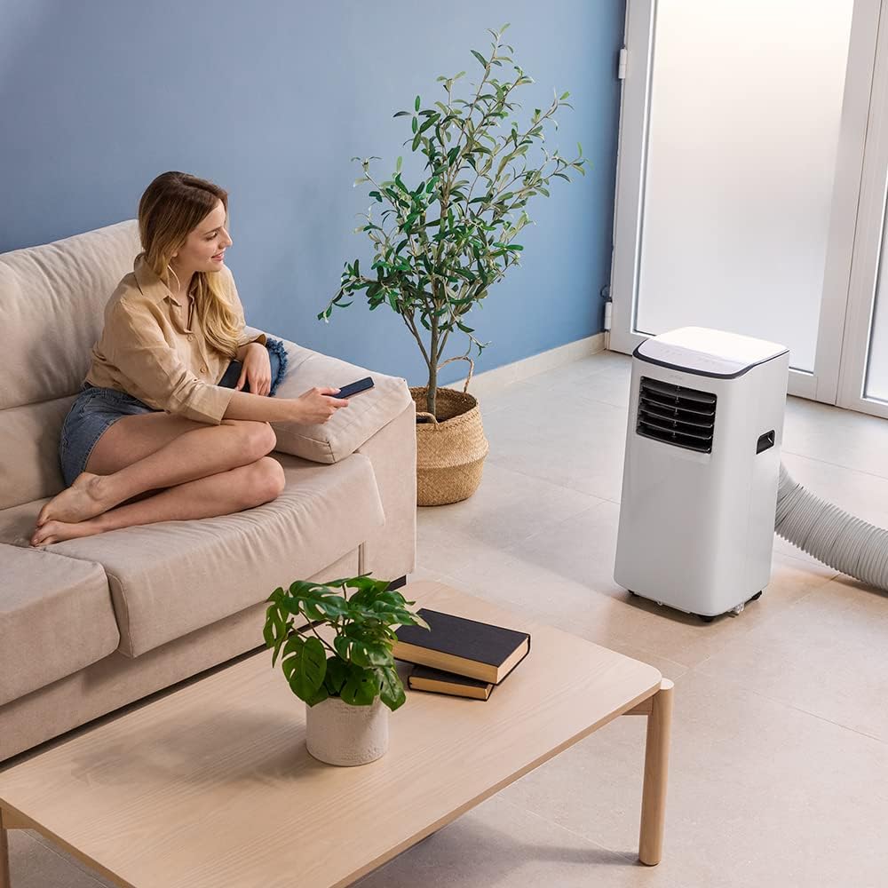 Woman relaxing with portable air conditioner in living room