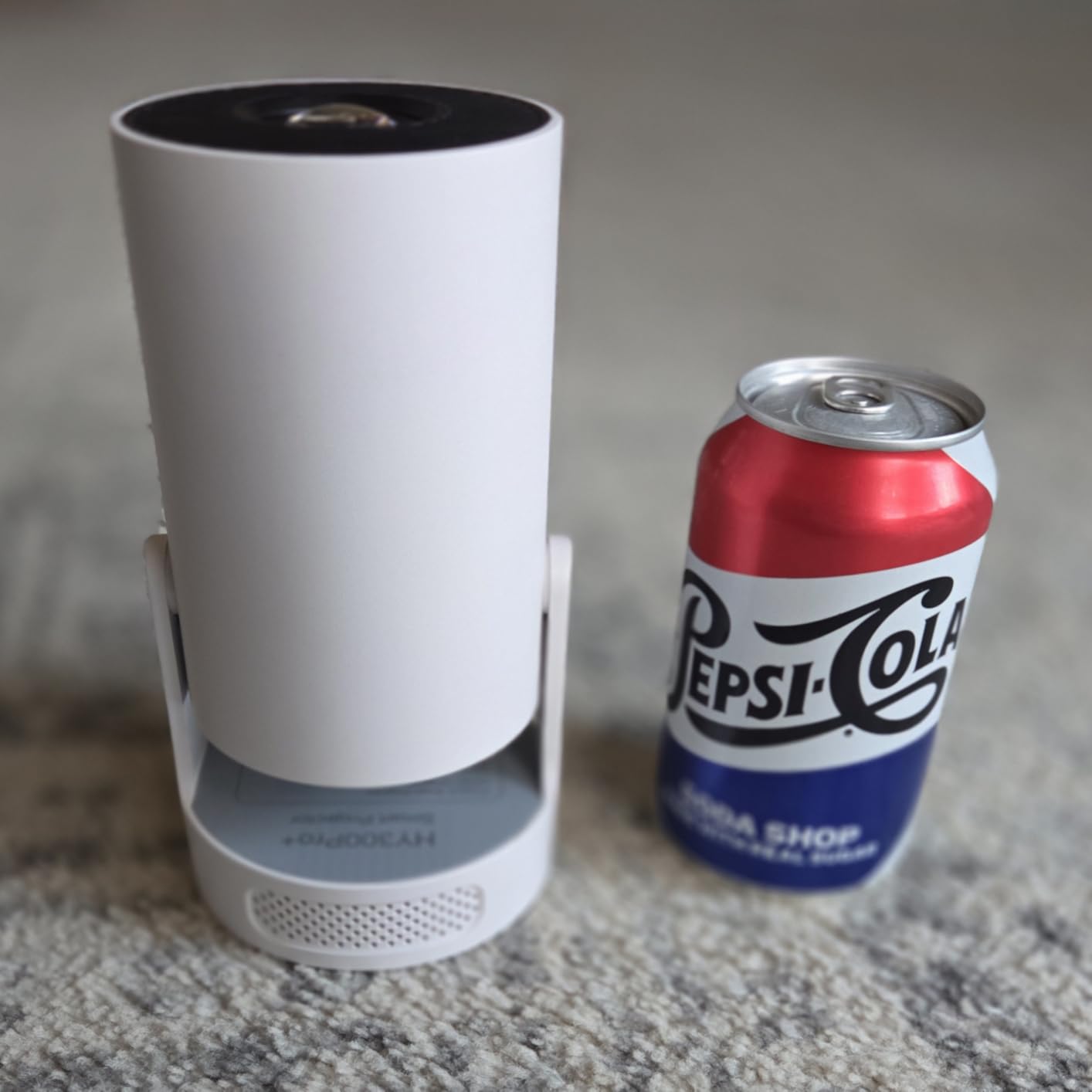 Magcubic projector compared to a Pepsi can for size reference