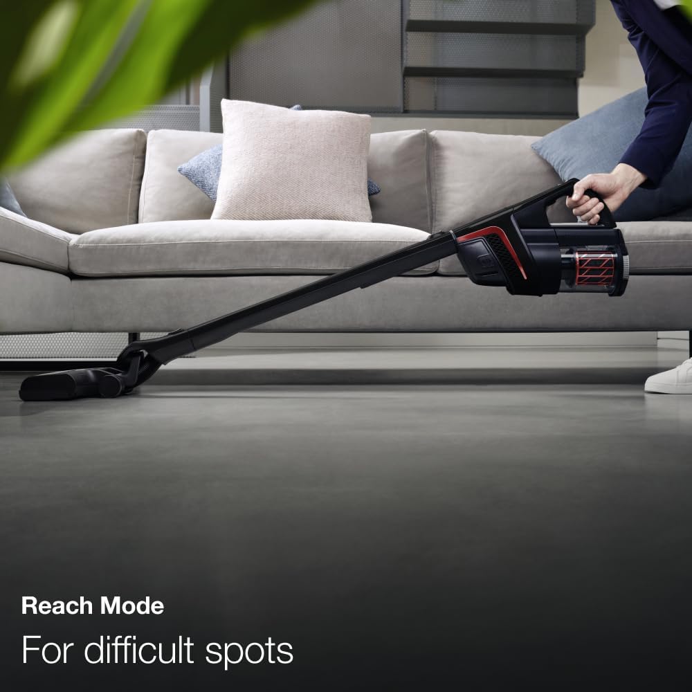 A person using the Miele Triflex HX1 in Reach Mode, extending under furniture.