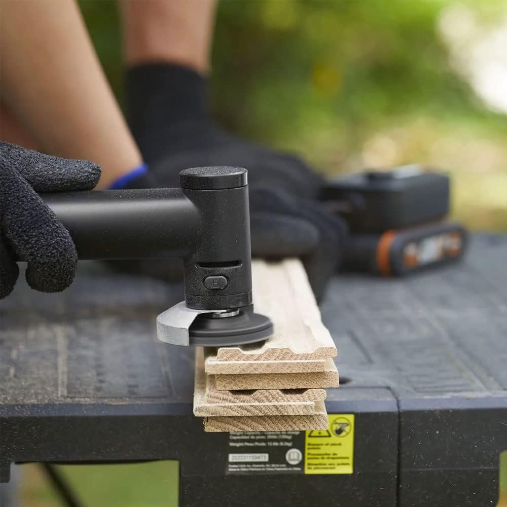 A person using the WORX MakerX Mini Grinder with a sanding attachment on a piece of wood.