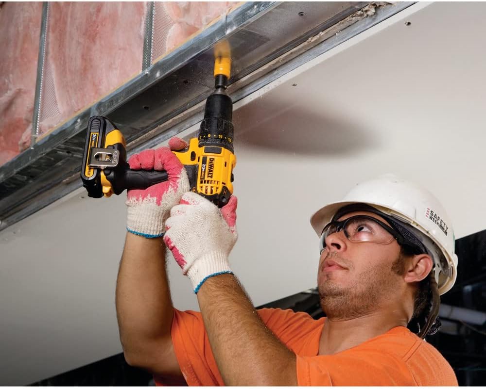 Worker using DEWALT DCD780C2 drill to fasten something overhead
