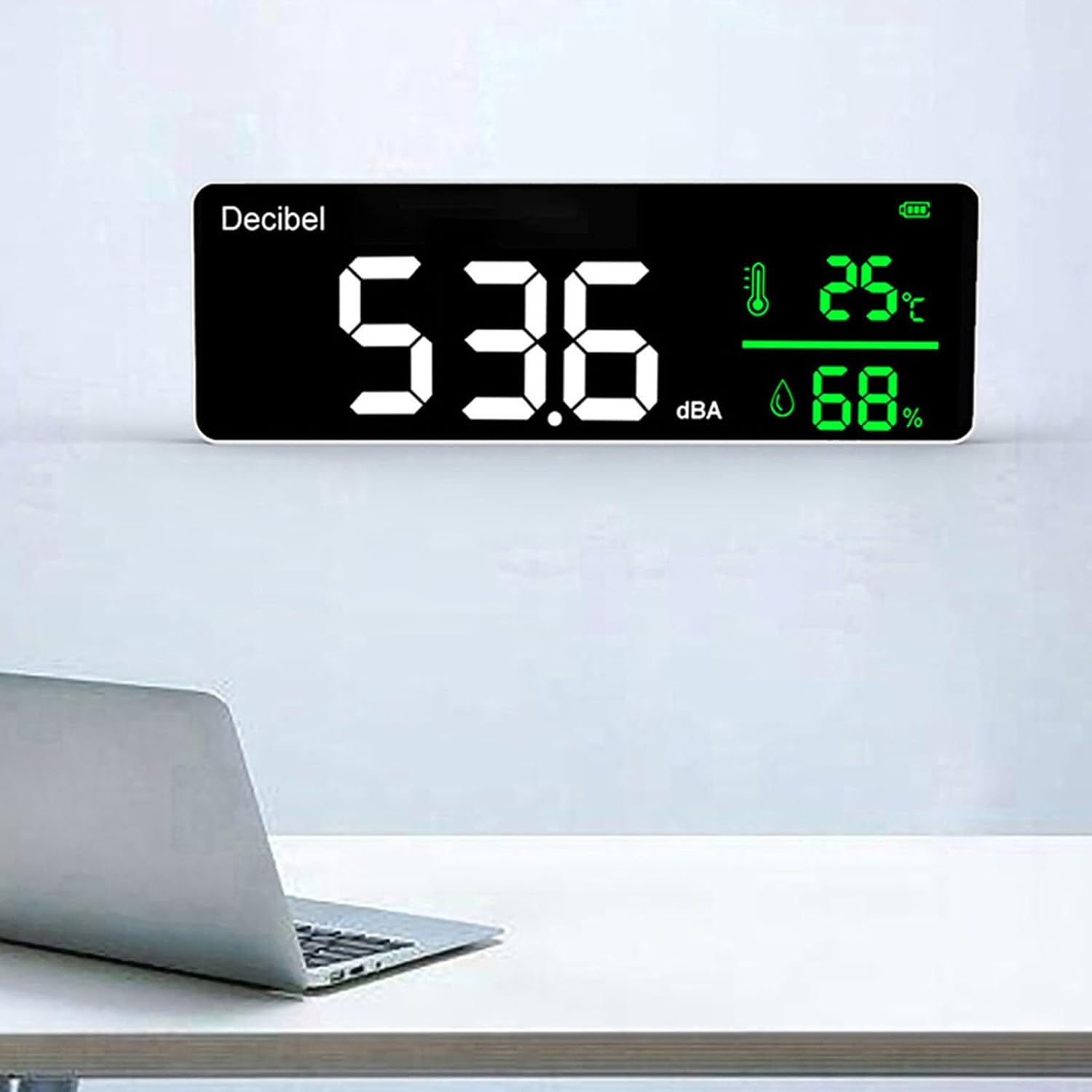 Yunseity Decibel Meter mounted on a white wall above a laptop.