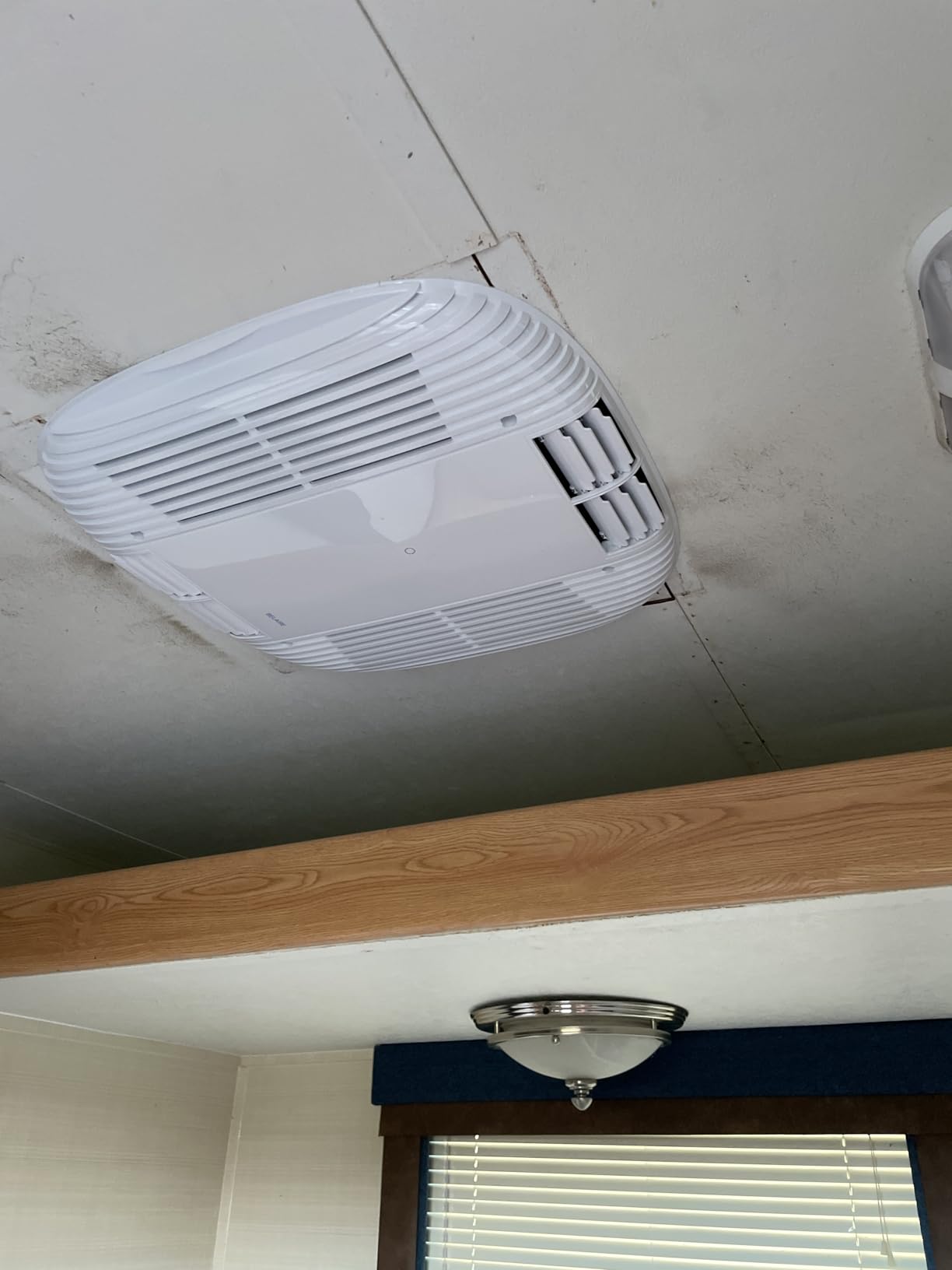 RecPro RV Air Conditioner 15K installed on an RV roof in a quiet campsite setting
