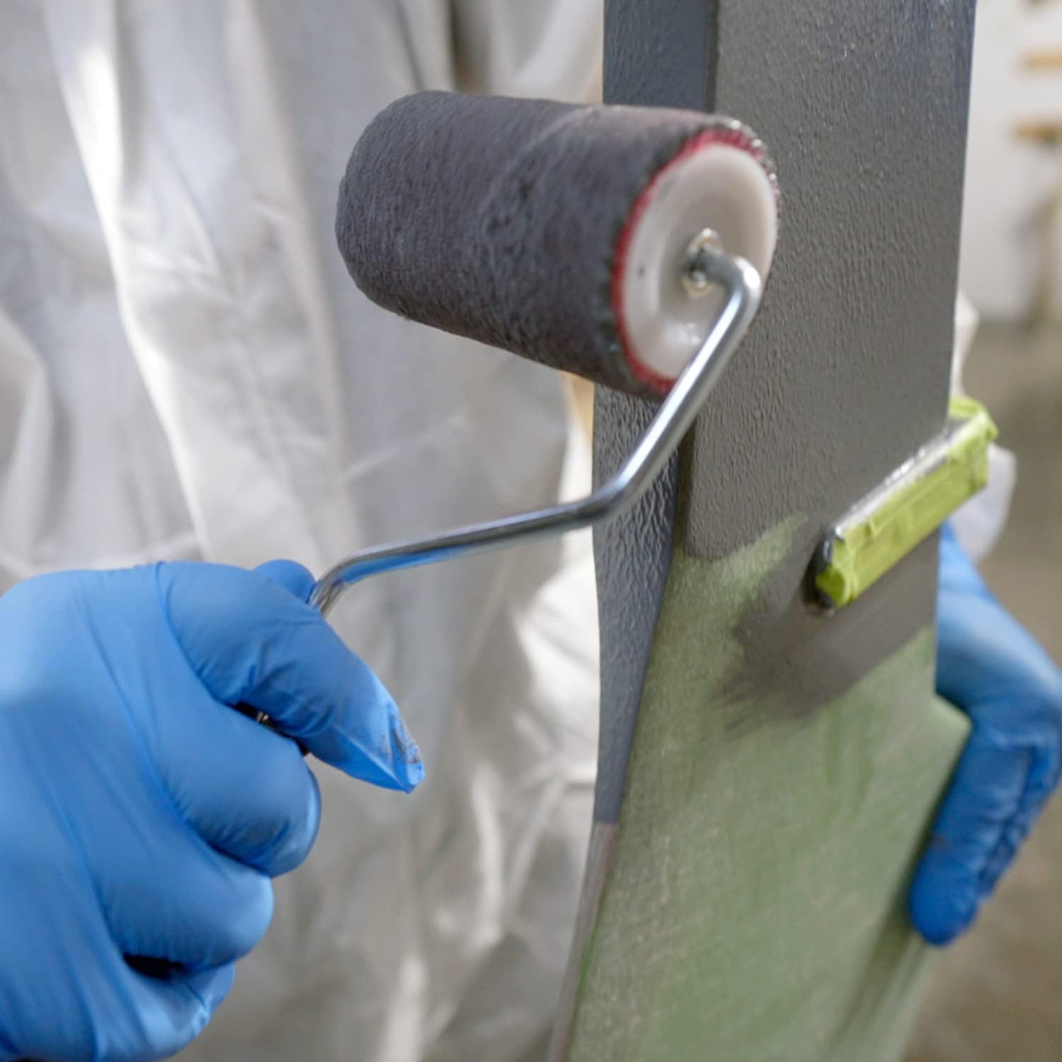 Close-up of a person rolling TotalBoat TotalProtect epoxy primer onto a surface