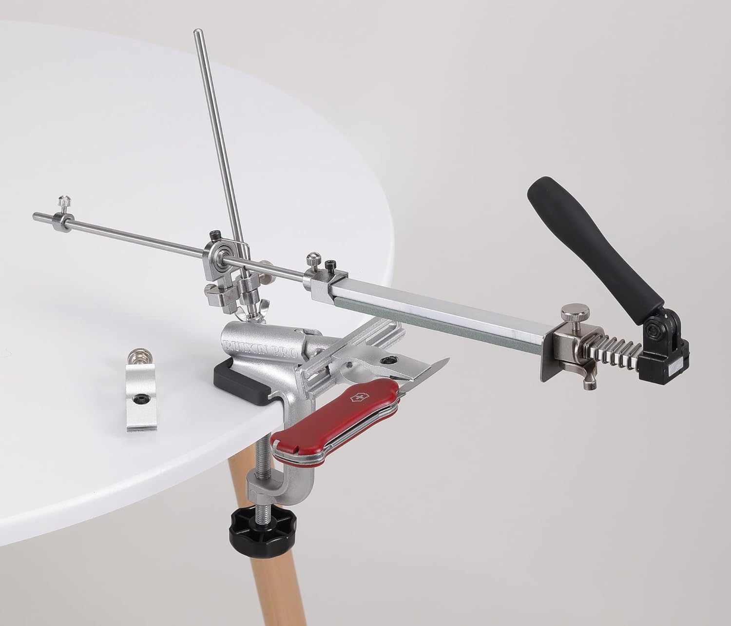 The RUIXIN PRO RX-009 Knife Sharpener holding a small multi-tool knife, showcasing its ability to sharpen compact blades.