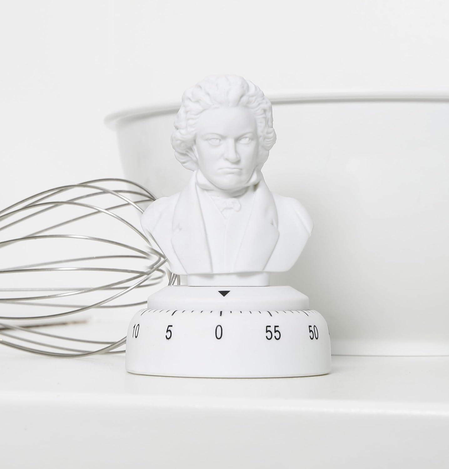 Beethoven Kitchen Timer placed on a white kitchen counter next to a metal whisk and a white bowl.