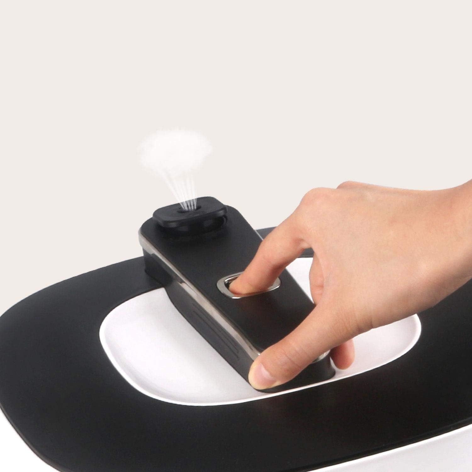 A hand pressing the steam release button on the Aigostar Panda Multicooker lid, demonstrating safe pressure release.