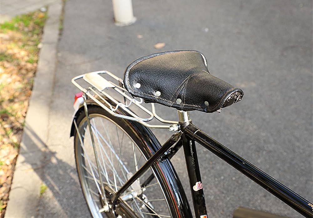 An Old Bicycle Seat With A Spring Shock Absorber. Vintage Bicycle On The Stone Wall Background Mnk8g6
