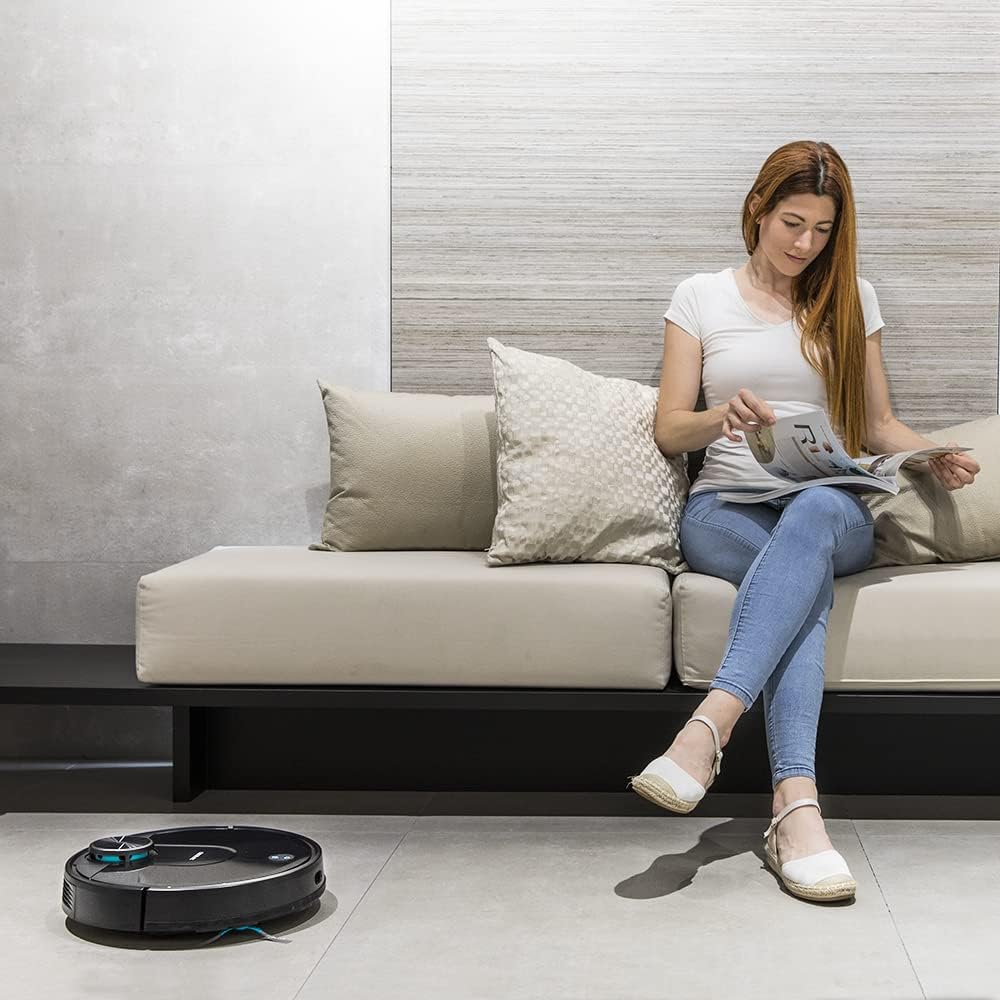 Woman relaxing on a sofa while the Cecotec Conga 3690 Absolute robot vacuum cleaner cleans the floor in the foreground.