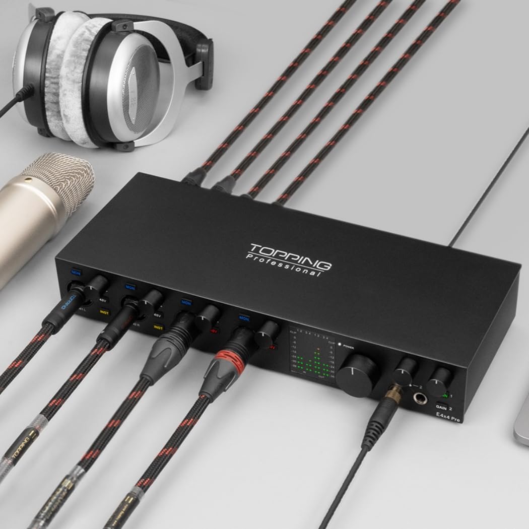 TOPPING E4X4 Pre USB Audio Interface in black, connected with multiple XLR cables for microphones and TRS cables for instruments, along with headphones and a laptop.