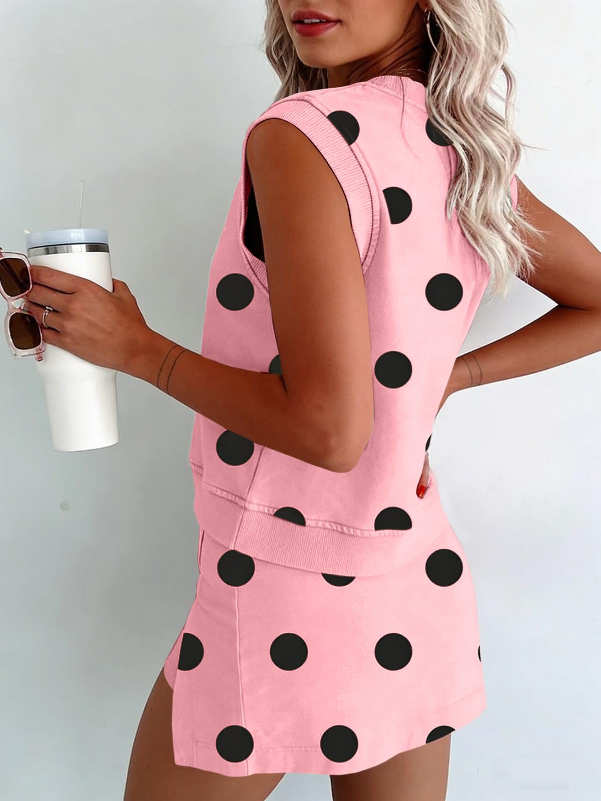 Conjunto de dos piezas: Top sin mangas con estampado de lunares y ribete acanalado, y minifalda-pantalón con abertura lateral. Estilo lindo y desenfadado.