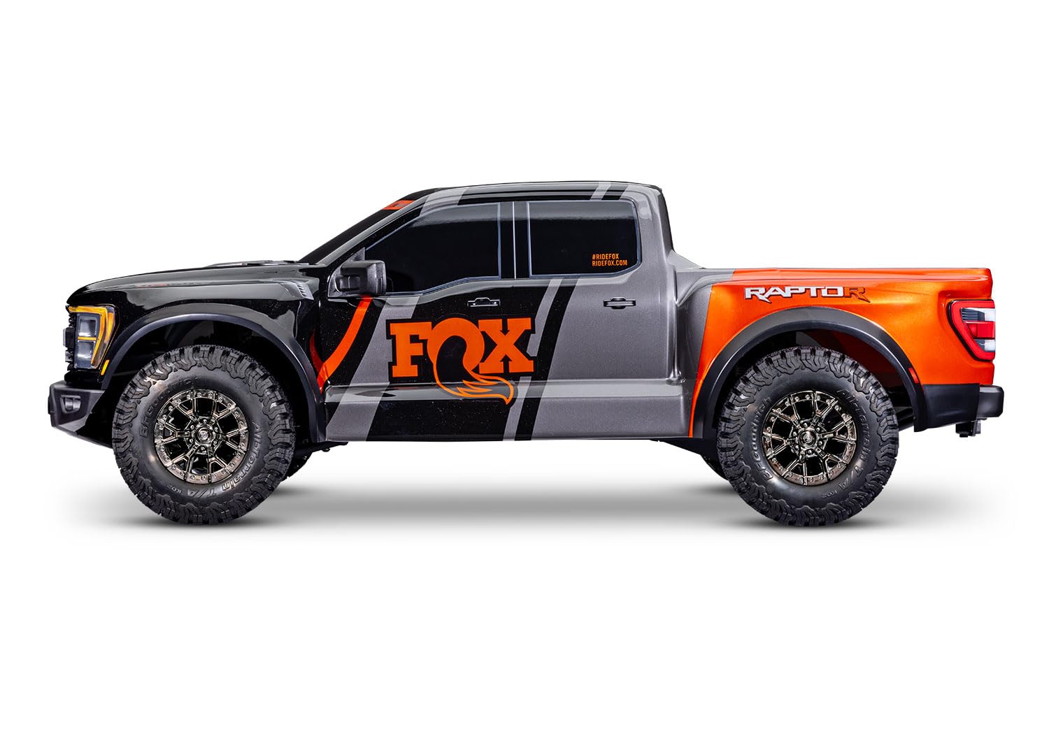 Traxxas Ford Raptor R 4X4 Ultimate remote control truck, rear view, showing orange and black body with Fox branding.